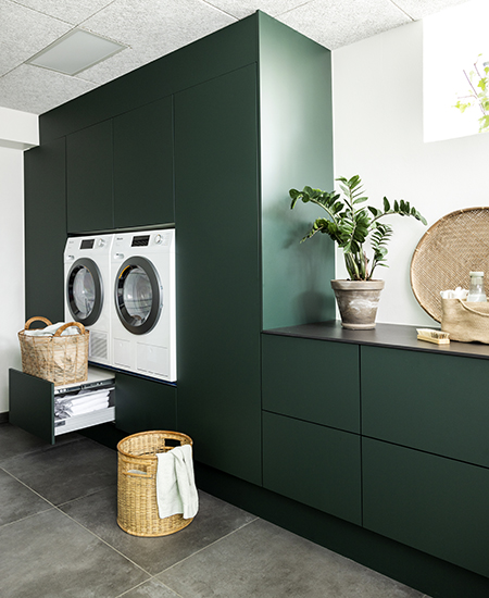 aubo sense bryggers i grøn med sort bordplade i kompaktlaminat med vaskemaskine og tørretumbler
